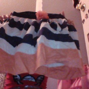 a pink, blue, and white skirt with a pink flower.